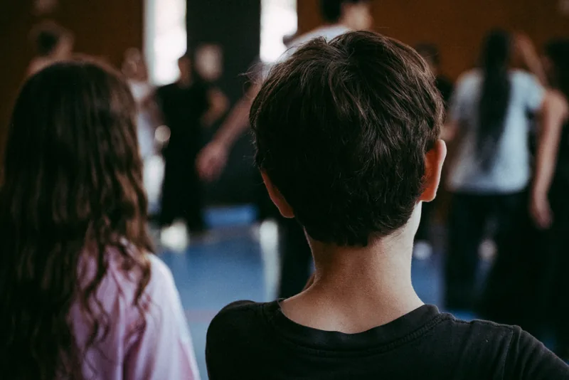 Vue de dos, jeunes danseurs face au plateau